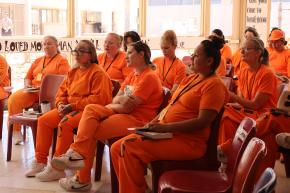 A group of incarcerated women sit down with books for a discussion with the Freedom Reads team in Arizona State Prison Complex – Perryville.