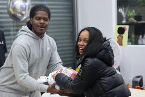 Team member from Brownsville Community Justice Center handing Thanksgiving turkey to community member.