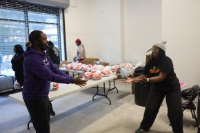 Brownsville Community Justice Center team members handing off Thanksgiving turkey at giveaway event.