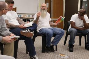 Man holding a copy of Tess Gunty's "The Rabbit Hutch" during Inside Literary Prize discussion circle in North Dakota State Penitentiary.