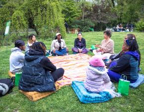 Group of people sit in a mindfulness circle in Brooklyn's Prospect Park for RISE's Mindful Moments in the Park day.