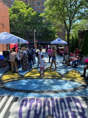 A group of community members walk around a painted courtyard at an event