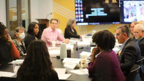 Photo of people conversing at roundtable.